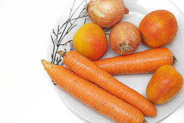 Prato de saladas de cenoura tomate e cebola no prato.
