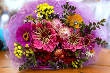 Obraz na płótnie Canvas Beautiful bouquet of pink flowers in gift box lying on table. Unexpected gift. Pleasant romantic surprise.