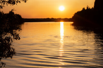 Fototapeta na wymiar Sunset on the lake among the trees.