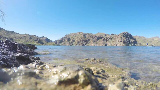 Low angle of Saguaro Lake with boats and fisherman.