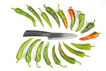 ceramic knife and green hot peppers on a white background. cooking vegetables for food
