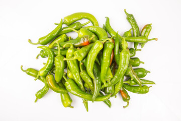 green hot peppers evenly spread on a white background. vitamin vegetables for health