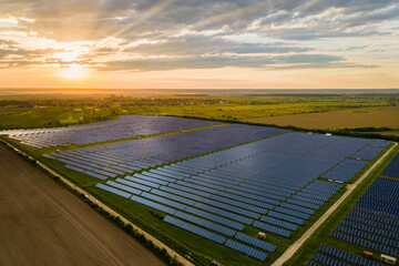 Aerial view of large sustainable power plant with many rows of solar photovoltaic panels for...