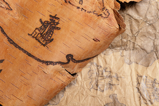Scraps of old nautical charts on paper and birch bark depicting sailing ships.