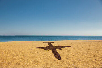 Schatten eines Flugzeugs über einem Strand