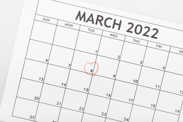 top view of march 2022 calendar with drawn heart around 8 march date isolated on white