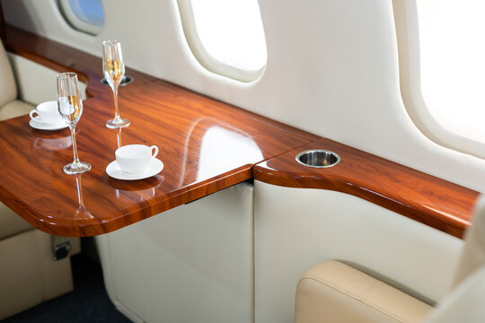 Cabin of luxury private jet. Empty aircraft with white leather chairs.