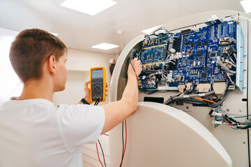 the engineer measures the voltage in the electrical appliance.
