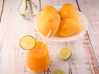 Mango mocktail with lime slice and plate of mango and lime © ALEKSEI