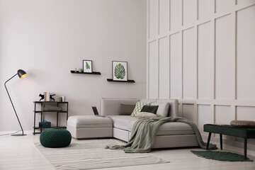 Living room with comfortable grey sofa and stylish interior elements