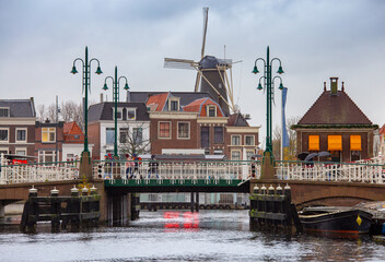 An old wooden mill on the banks of a canal in Leiden at dawn.