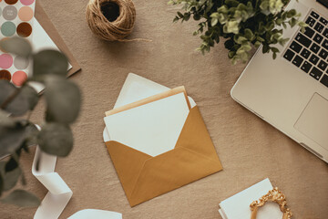 op view of a wedding invitation with gold envelope and brown background