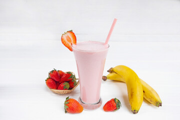 Strawberry and banana smoothie colorful fruit juice milkshake blend beverage healthy high protein the taste yummy In glass drink episode morning on a wooden background.