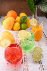 Multicolor mocktails with ice. Strawberry mocktail lime mocktail on wooden table