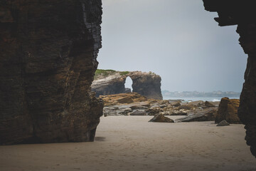 stone arch in the sea, with two rocks in the foreground