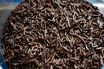 Chocolate sprinkles background ( chocolate granulado ), sweet food, candy. Ingredient used to make brigadeiro cake, pot cake and chocolate sweets. Selective focus, Close up
