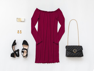 Red mini evening dress, small black bag with chain strap and heeled sandals on white background....