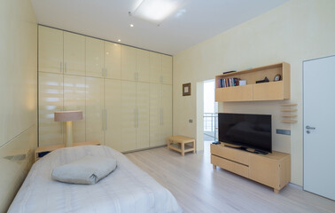 Modern scandic interior in beige tones of bedroom in luxury apartment.