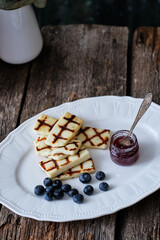 Grilled halloumi cheese with blueberries and jam.