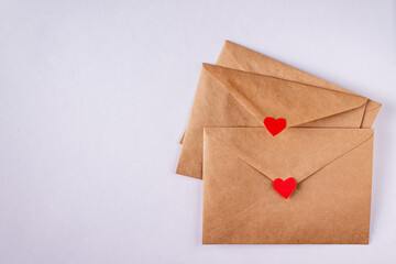 craft envelopes with red paper hearts on white background, copy space