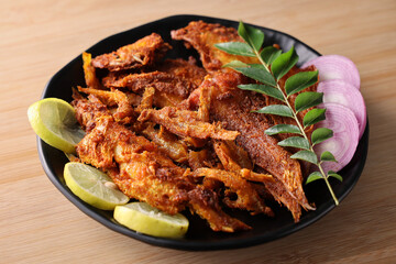 Fried fish in Kerala India. Indian seafood anchovy fry with spices and lime. Tasty fish food. 
