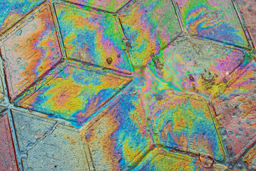 Oil stains on wet asphalt. Puddles are contaminated with multicolored streams of oil. The concept of environmental pollution, oil spills and environmental problems.