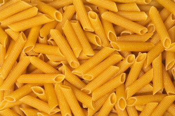 Full frame studio macro shot with top view of dry penne pasta