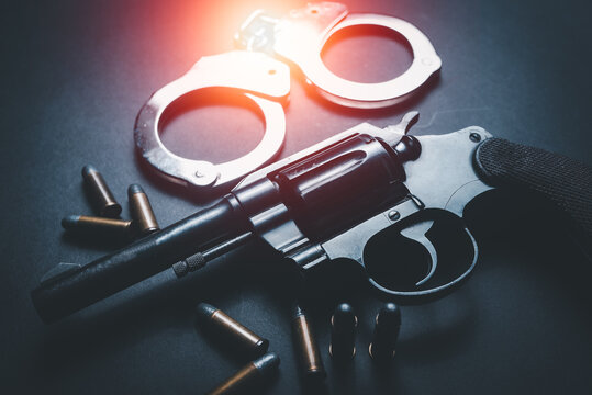 Guns, ammunition and shackle placed in a dark table,Short guns, ammunition and shackle placed on a black background table,Guns and ammunition are ready to use. Noisy weapon