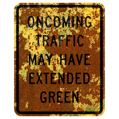 Old rusty American road sign - Oncoming traffic may have extended green