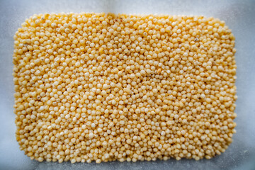Millet close-up. Wine on top of cereals. Millet porridge of yellow color.