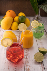 Colored mocktails, oranges, lemons, limes, mango Vase with