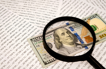 Dollars and money estimate through a magnifying glass close-up. Finance and business. Financial...