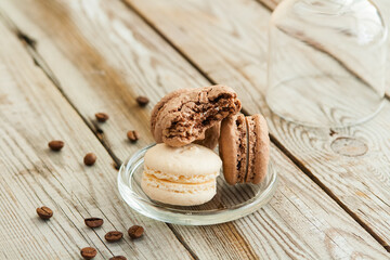 Coffee and coconut macarons on wooden background