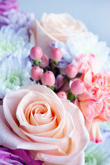 A beautiful delicate bouquet of roses, hyperium and dianthus on a lilac background. Floral background