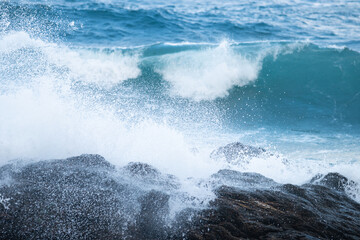 Fototapeta premium Man walking on a cloudy day on a beach with churning water