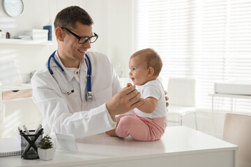 Pediatrician examining cute little baby in clinic. Space for text