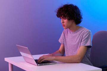 curly guy in front of laptop entertainment violet background