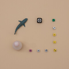 Cubes of various sizes and colors with a gray shark on a beige background with copy space. Minimal flat lay scene.