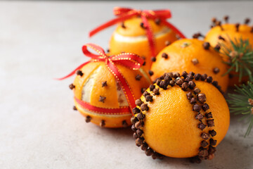 Pomander balls made of tangerines with cloves on grey table, closeup. Space for text