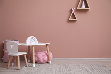 Cute child room interior with furniture, toys and wigwam shaped shelves on pink wall
