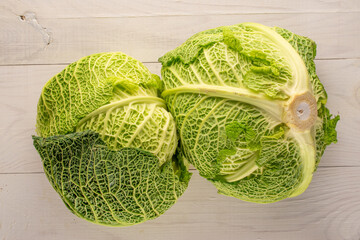 Two bales of juicy Savoy cabbage on a wooden table , macro, top view.