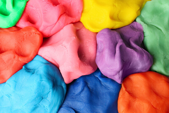 Different color play dough as background, top view