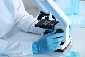 Scientist working with microscope at table, closeup. Medical research