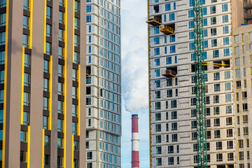 Fototapeta premium Residential buildings located close to the steaming pipes of thermal power plant.