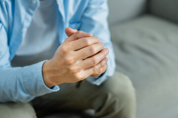 Fototapeta premium man sitting at home holding hands praying for blessings from god