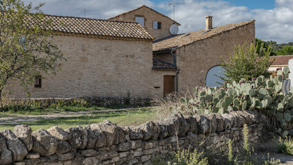 Fototapeta na wymiar Large winery building with cacti in front and a stone wall