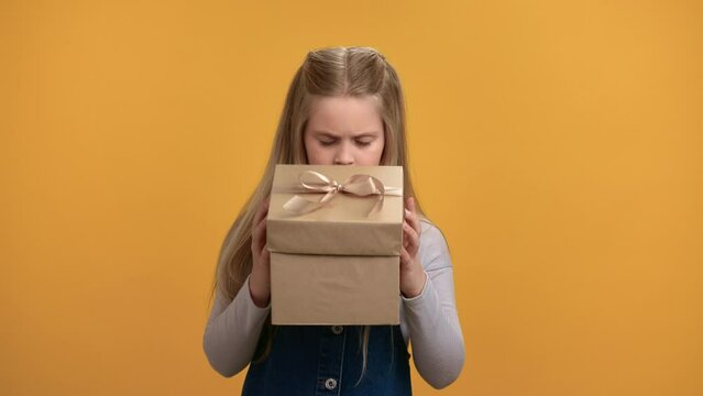 Portrait smiling baby girl open craft gift box with bad present inside having negative emotion 