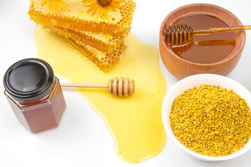 Fresh flower honey in a wooden bowl, spoon, pollen and honeycomb. vitamin food for health and life