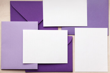 Envelopes pile with empty cards. Group of purple envelopes on brown table. Set of purple envelopes...