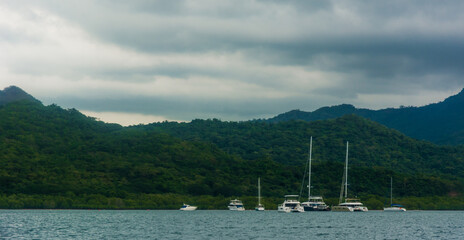Yachts on a blue beach with mountain background